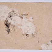 A piece of handmade paper with paint splatter on it