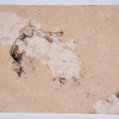 A piece of handmade paper with paint splatter on it