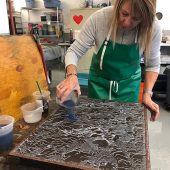 A woman pouring paper pulp into a mold