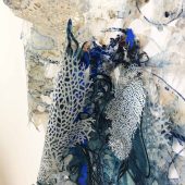 Pieces of cut out mylar and fabric on paper