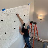 A man putting Velcro circles on an art template