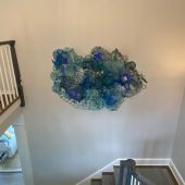 A mixed media art sculpture on a wall in a stairwell