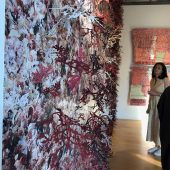 A woman looking at a 3D art sculpture in a gallery