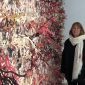 A woman standing next to a 3D art exhibit