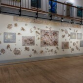 Hear the Ocean Sobbing A wall in an art gallery with art pieces on it