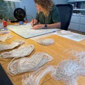 A woman cutting masks from washi paper