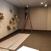 Installing the custom wallpaper A woman on a ladder hanging wallpaper