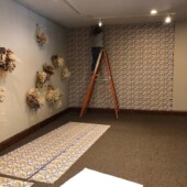 Installing the custom wallpaper A woman on a ladder hanging wallpaper