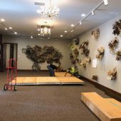 Installing the floor for Hello Sailor Two men and a woman setting up a floor platform in an art gallery.