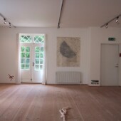 A room with art pieces made from paper on the walls