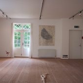 A room with art pieces made from paper on the walls