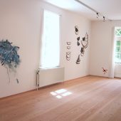 A room with french doors and art hanging on the walls