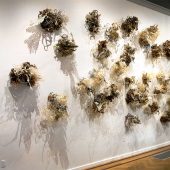 Mixed media art sculptures on a wall in an art gallery