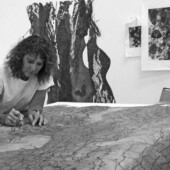 Black and white photo of Joan Hall working on a project in her studio.