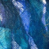 Close up of a wall hanging made from paper, mylar and netting