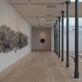 An art exhibit with mixed media art on the walls, floor and ceiling